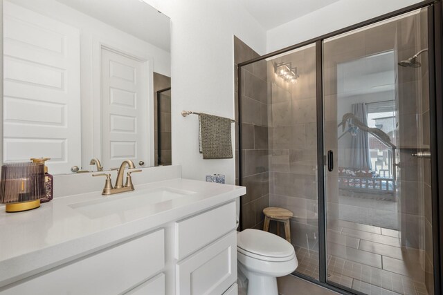 bathroom featuring vanity, a shower stall, and toilet