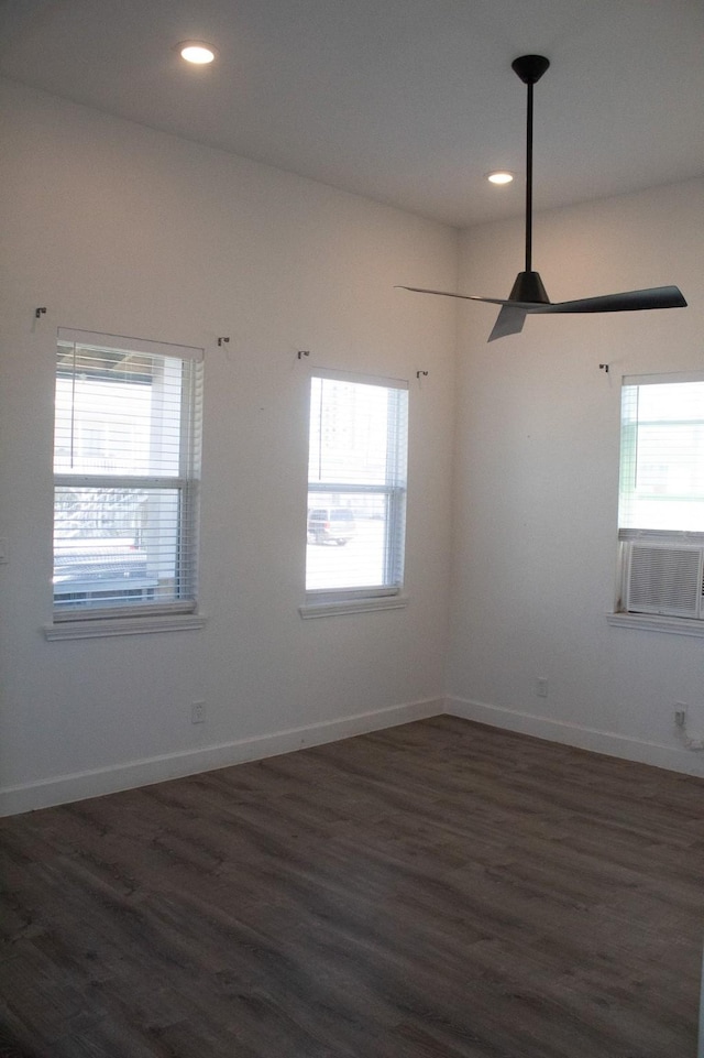 unfurnished room with plenty of natural light, dark wood-type flooring, and baseboards