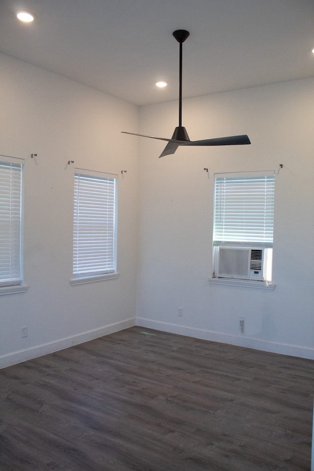 empty room featuring recessed lighting, cooling unit, dark wood-type flooring, and baseboards