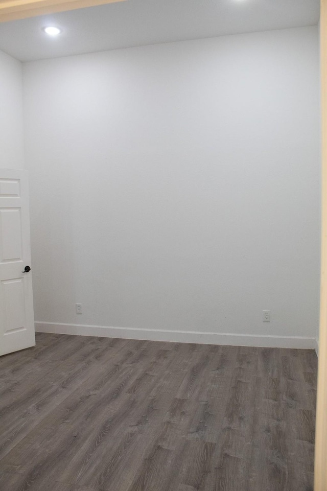 unfurnished room featuring recessed lighting, dark wood-type flooring, and baseboards