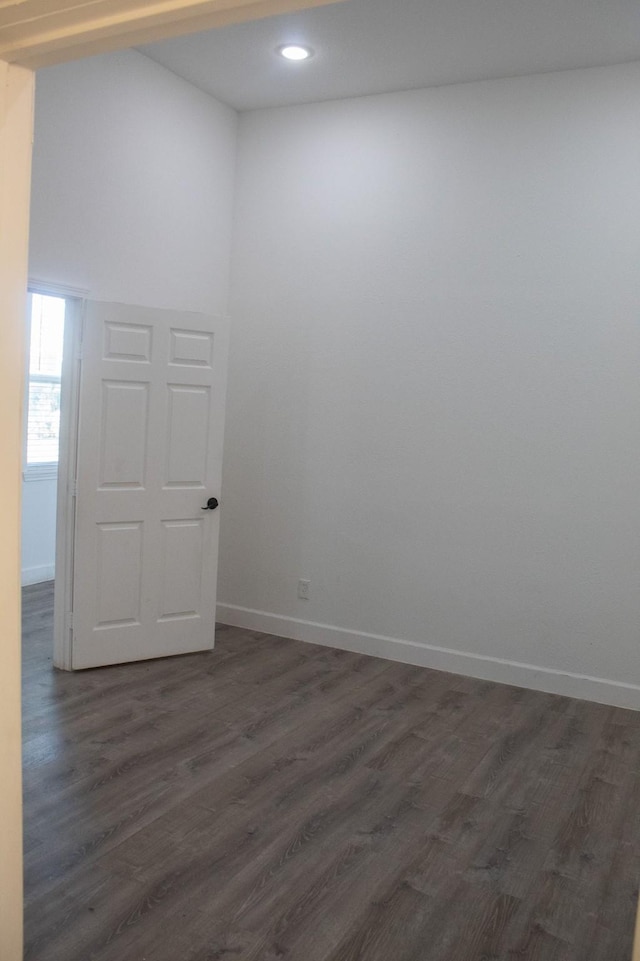 spare room with dark wood finished floors, recessed lighting, and baseboards