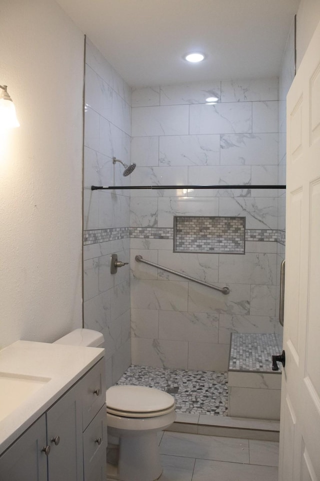 full bath featuring a tile shower, recessed lighting, toilet, and vanity