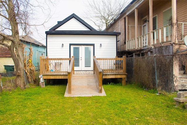 rear view of property with french doors, a lawn, and a deck