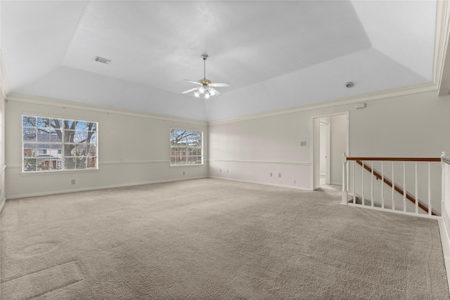 empty room featuring a ceiling fan, lofted ceiling, light colored carpet, and visible vents