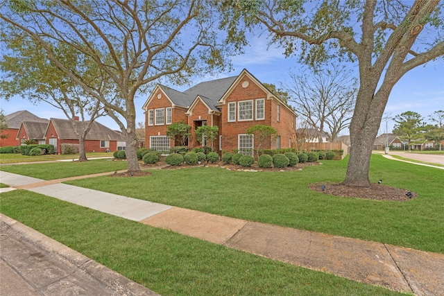 traditional home featuring brick siding and a front yard