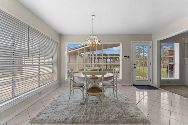 tiled dining room with an inviting chandelier and baseboards