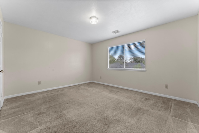 carpeted empty room with visible vents and baseboards