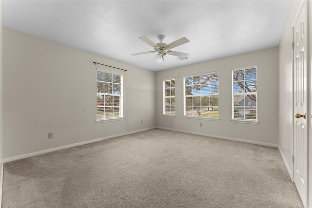 unfurnished room featuring plenty of natural light, light colored carpet, and baseboards