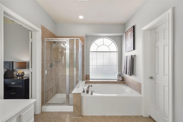 bathroom featuring tile patterned floors, a garden tub, a stall shower, and vanity