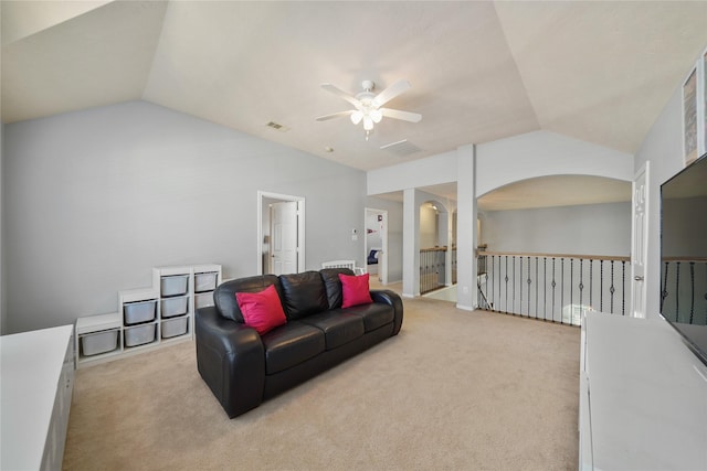 living room featuring lofted ceiling, arched walkways, light carpet, and a ceiling fan