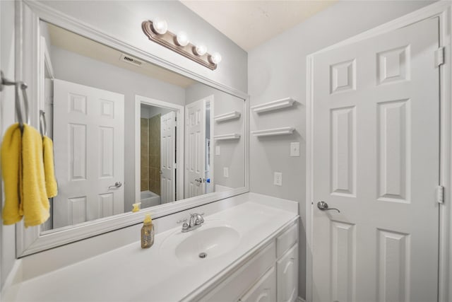 bathroom featuring visible vents, a bath, and vanity