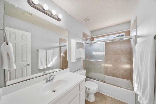 bathroom with tile patterned flooring, visible vents, toilet, vanity, and a textured ceiling