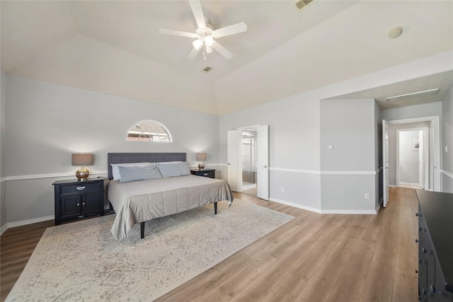 bedroom featuring visible vents, light wood-type flooring, baseboards, and vaulted ceiling