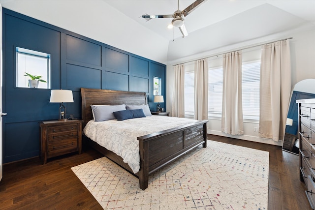 bedroom featuring a decorative wall, ceiling fan, lofted ceiling, and dark wood-style flooring