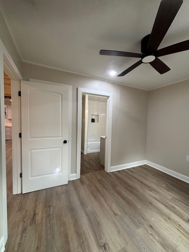 unfurnished room with wood finished floors, ceiling fan, and baseboards