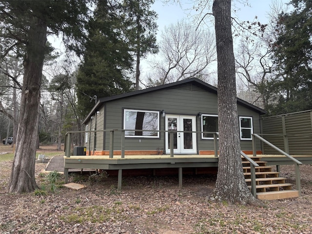 rear view of house with french doors, cooling unit, and a deck