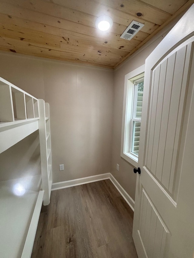 unfurnished bedroom with visible vents, baseboards, wooden ceiling, and dark wood-style floors