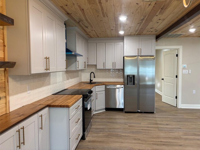 kitchen with light wood finished floors, wooden ceiling, wood counters, and stainless steel appliances