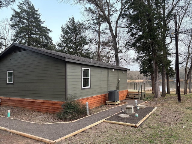 view of side of property featuring a water view and cooling unit