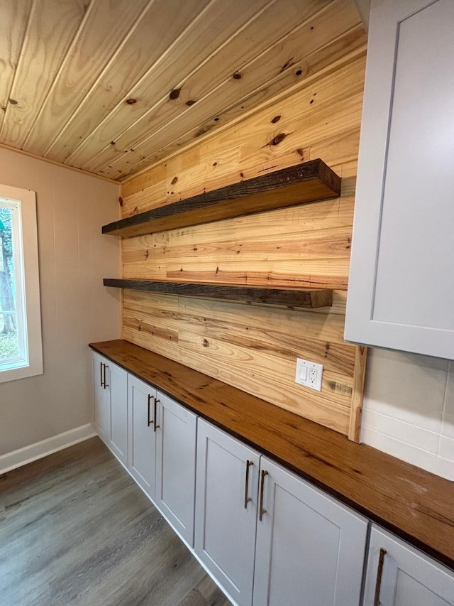 interior space with dark wood finished floors, wooden walls, and wooden ceiling