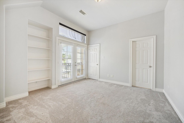 carpeted spare room with visible vents, french doors, baseboards, and built in features