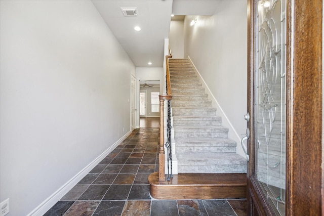 staircase featuring recessed lighting, visible vents, baseboards, and stone finish floor