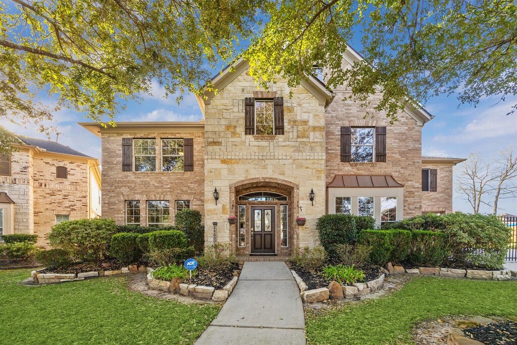 24600 Belvon Valley Ln, Porter, TX 77365 - view of front of property featuring stone siding, brick siding, and a front lawn