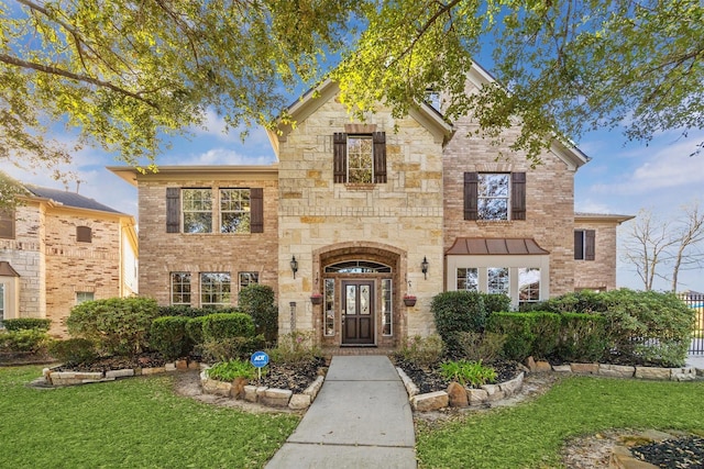 view of front of property featuring stone siding, brick siding, and a front lawn