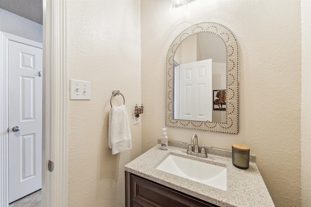 bathroom with vanity and a textured wall