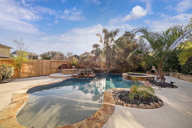 view of swimming pool featuring a pool with connected hot tub, a patio, and fence