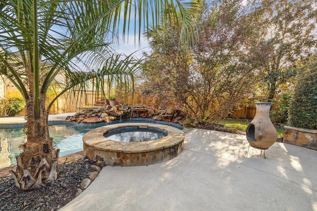 view of patio / terrace with a fenced in pool and an in ground hot tub