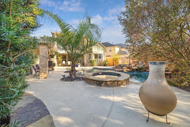 view of swimming pool with a patio, a pool with connected hot tub, and fence