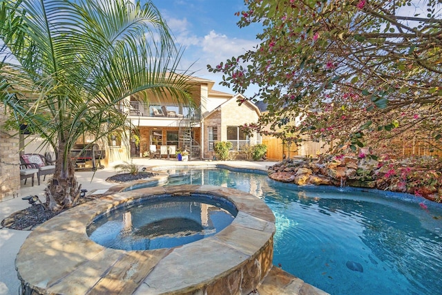 pool featuring a patio, an in ground hot tub, and fence