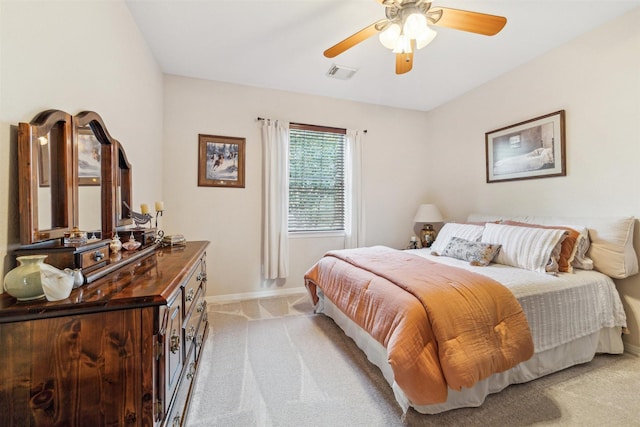 bedroom with light carpet, visible vents, a ceiling fan, and baseboards