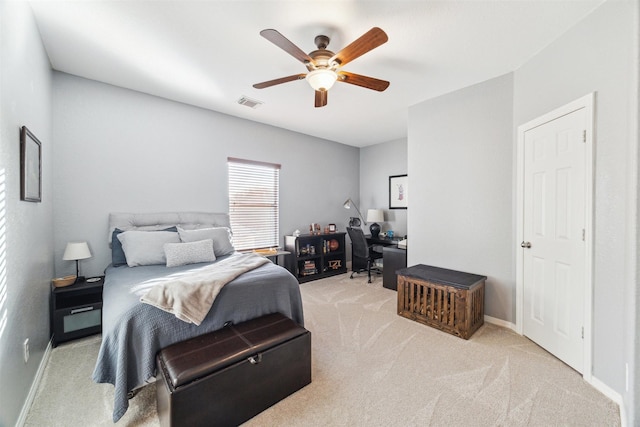 bedroom with visible vents, baseboards, light colored carpet, and a ceiling fan