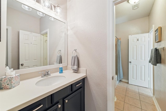 bathroom with visible vents, shower / bathtub combination with curtain, tile patterned flooring, baseboards, and vanity