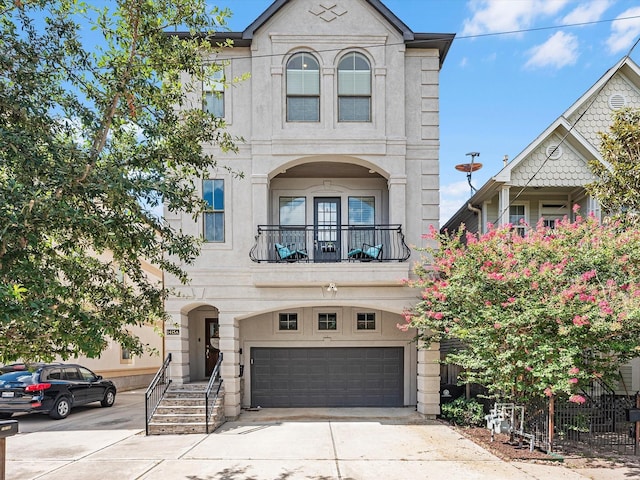 view of front facade featuring a garage, a balcony, and concrete driveway