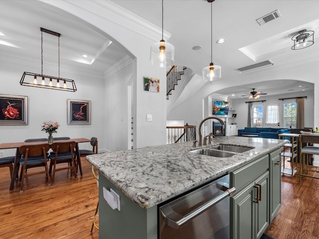 kitchen featuring visible vents, crown molding, dishwasher, arched walkways, and a sink