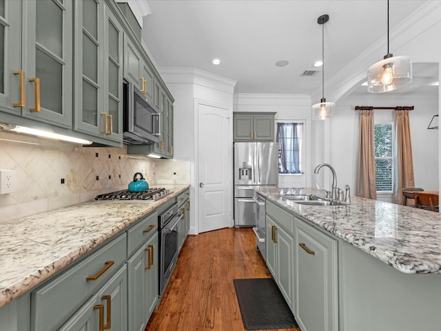 kitchen with crown molding, visible vents, stainless steel appliances, and a sink