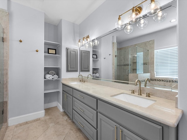 full bath featuring double vanity, baseboards, a stall shower, and a sink