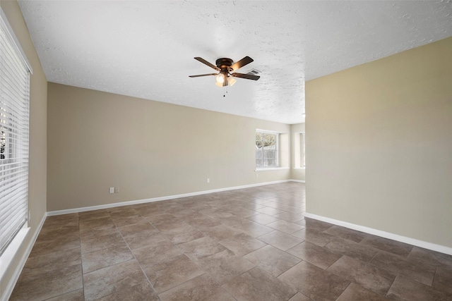 spare room featuring baseboards, a textured ceiling, and ceiling fan