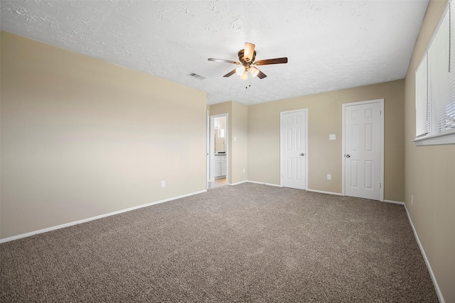 carpeted spare room featuring visible vents, ceiling fan, a textured ceiling, and baseboards