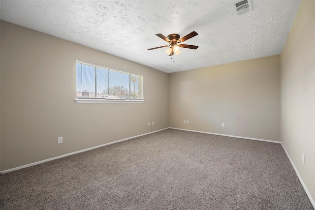 empty room with visible vents, a ceiling fan, a textured ceiling, carpet, and baseboards