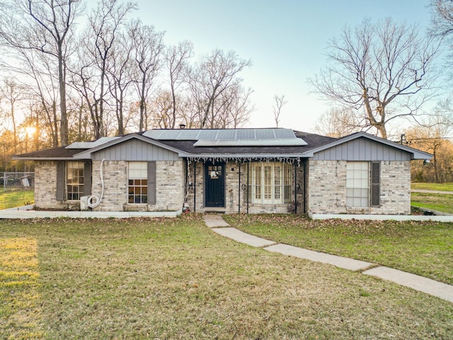 17866 Magnolia Ln, New Caney, TX 77357 - ranch-style house featuring roof mounted solar panels, brick siding, and a shingled roof