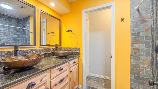 17866 Magnolia Ln, New Caney, TX 77357 - bathroom featuring tiled shower, baseboards, and double vanity