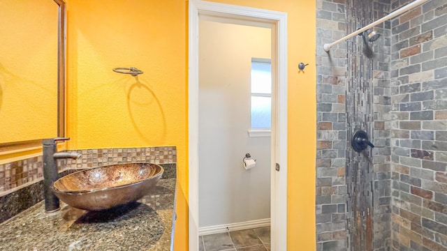 17866 Magnolia Ln, New Caney, TX 77357 - bathroom featuring a tile shower, a sink, and baseboards