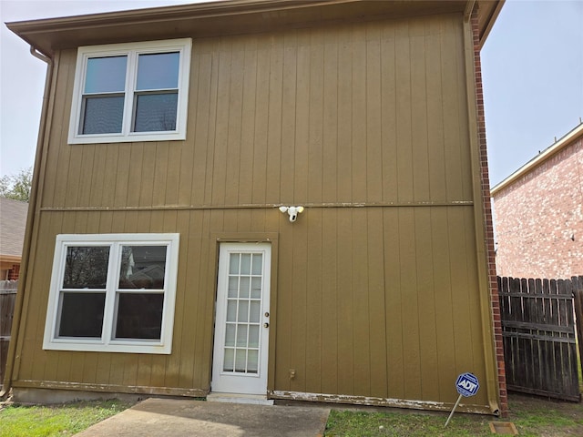 rear view of property with an outbuilding and fence