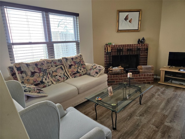 living area featuring a brick fireplace and wood finished floors