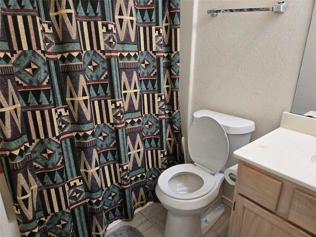 full bath featuring vanity, a shower with curtain, toilet, and a textured wall