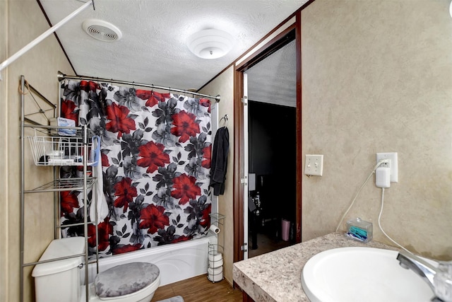 full bathroom with visible vents, toilet, wood finished floors, shower / bath combination with curtain, and a textured ceiling